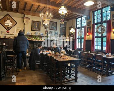 In einer ruhigen Straße in der Nähe des Zentrums von Brügge, Belgien, könnte ein Fußgänger sogar das Cafe Vlissinghe verpassen, auf einem Foto vom 21. Dezember 2023. Aber wer den Eingang zum kleinen Café in der Blekersstraat entdeckt, wird sich auf eine Reise in die Vergangenheit begeben. Das Café ist die älteste Einrichtung dieser Art in Brügge und eines der ältesten der Welt. Sie ist seit 1515 in Betrieb, laut Aufzeichnungen des Rathauses. So feierte sie vor kurzem ihren 500. Jahrestag und hat, wie die Einheimischen sagen, Kriege und Revolutionen überlebt. In der Vergangenheit wurde es von berühmten Künstlern wie dem Flämischen besucht Stockfoto