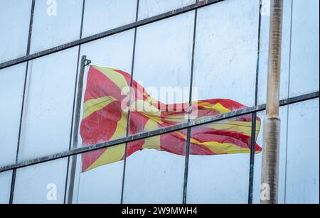 Mazedonische Flagge. Winkende Reflexion, in den Glasfensterrahmen. Muster und Textur. Stockfoto