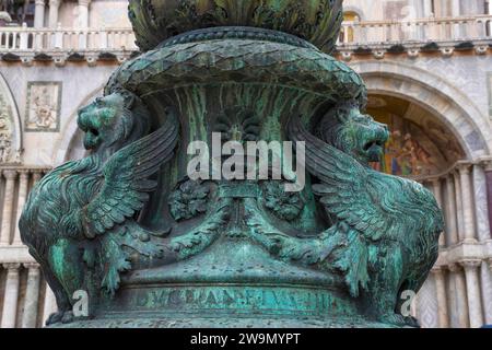 Altes Straßenschmuck mit geflügelten Löwen und Markusdom im Hintergrund, in St. Markplatz, berühmte Touristenattraktion in Venedig, Italien. Wählen Sie Stockfoto
