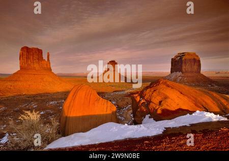 Blick auf West Mitten Butte, East Mitten Butte und Merrick Butte, Monument Valley, Schneestücken bei Sonnenuntergang im Winter, Arizona, USA Stockfoto