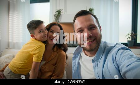 Glückliche kaukasische Familie spricht über Online-Videoanruf Welle Hallo Gruß Blick auf Webcam Vater Mutter Sohn Blogger Aufnahme Vlog Eltern Kind Junge Stockfoto