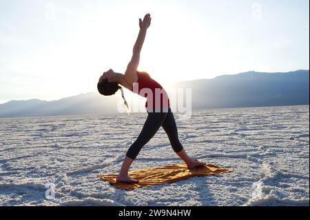 Eine junge Frau führt Yoga im Badwater Basin im Death Valley National Park, CA. Stockfoto
