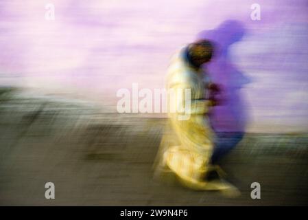 Eine abstrakte Ansicht eines Mannes in einer Djellaba, der in Tanger, Marokko, spaziert. Stockfoto