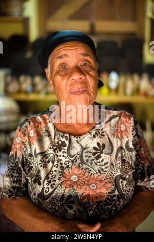 Ein Porträt einer Kalinago-Frau in ihrem Korbladen im Touna Kalinago Heritage Village im Kalinago-Territorium auf der Karibikinsel Dominica. Stockfoto