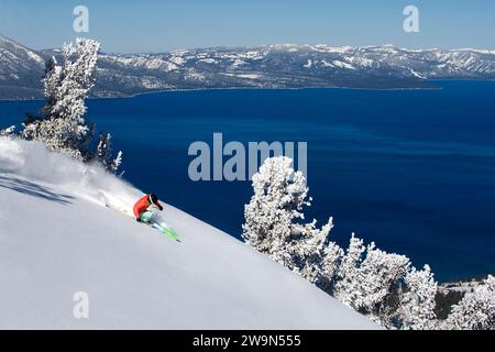 Eine Skifahrerin (Hazel Birnbaum) fährt an einem wunderschönen Tag im Heavenly Mountain Resort mit Lake Tahoe im Hintergrund in der Nähe von South Lake Tahoe, Kalifornien. Stockfoto