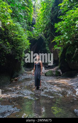 Frau, die den Canyon in der Nähe des Tukad Cepung Wasserfalls auf Bali erkundet Stockfoto