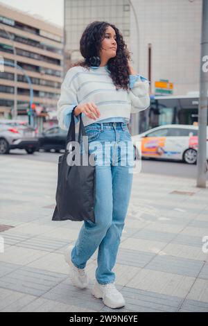 südamerikanerin mit Einkaufstasche, die auf der Straße läuft Stockfoto