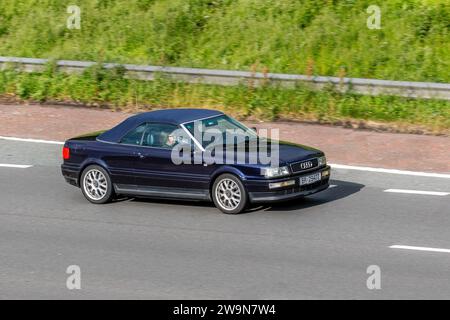 Audi 80 Kompaktwagen. Schwarz Deutsch Linkslenkung Audi Cabriolet auf der Autobahn M6 im Großraum Manchester, Großbritannien Stockfoto