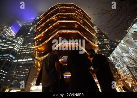 New York, Usa. Dezember 2023. Menschen stehen vor dem Schiff. Das Schiff ist ein modernes Wahrzeichen von New York City und befindet sich im Zentrum von Manhattan. Es ist eine Struktur und Besucherattraktion, die im Rahmen des Hudson Yards Redevelopment Project in Manhattan gebaut wurde. Die Leute konnten vorher auf das Schiff laufen, aber die Stadt hat es den Leuten verboten, das später zu tun. Als Wahrzeichen von New York City kommen jeden Tag viele Touristen auf das Schiff. Quelle: SOPA Images Limited/Alamy Live News Stockfoto