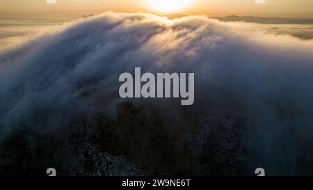 Sizilien 2023. Wolken, die über den Mount Santa Caterina auf der Insel Favignana klettern. Dahinter sehen wir die Sonne bei Sonnenaufgang. Juli 2023 Trapani, Italien Stockfoto