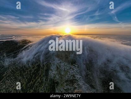 Sizilien 2023. Wolken, die über den Mount Santa Caterina auf der Insel Favignana klettern. Dahinter sehen wir die Sonne bei Sonnenaufgang. Juli 2023 Trapani, Italien Stockfoto