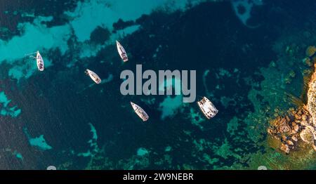 Sizilien 2023. Blick aus der Vogelperspektive auf kleine Boote, die in der Macari Bucht vertäut sind. Unter ihnen ist das Meer durchsichtig und Sie können die sandigen und felsigen Teile sehen. Juli 2023 T Stockfoto