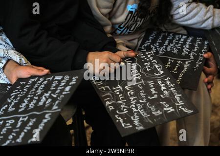 Rafah. Dezember 2023. Studenten studieren in einem temporären Klassenzimmer in Rafah im südlichen Gazastreifen am 28. Dezember 2023. Einige Schüler in Gaza haben in vorübergehende Klassenzimmer umgestiegen, da viele Schulen hier für die Unterbringung von Obdachlosen genutzt werden, die durch eine neue Runde des palästinensisch-israelischen Konflikts verursacht wurden. Quelle: Rizek Abdeljawad/Xinhua/Alamy Live News Stockfoto