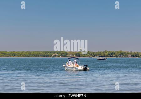 Motorboot in der Mittelkonsole von Blade zum und vom Strand bei Sonnenuntergang Stockfoto