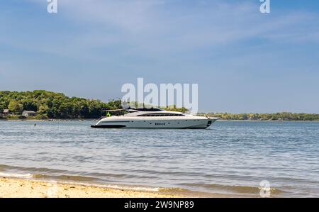 Teure Motoryacht vor Anker am Strand bei Sonnenuntergang Stockfoto