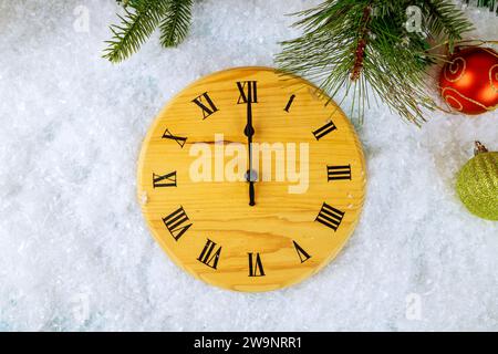 Weihnachtsbaumzweig des Tannenbaums mit festlichen Bällen Retro-Uhr im Hintergrund für Neujahr Stockfoto