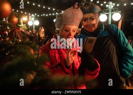 Moskau, Russland. Dezember 2023. Teilnehmer mit Karnevalsmasken nehmen an der Eröffnung des Neujahrs- und Weihnachtsfestes „Moskauer Estates“ Teil. Winter in Moskau, Russland. Das Festival findet vom 22. Dezember bis zum 08. Januar 2024 an 15 Orten in Moskau statt. Es umfasst mehr als 400 Veranstaltungen, Neujahrs- und Weihnachtsbällen, Kindervorführungen, Vorträge, Folklore-Feste, Quests, und Teepartys. Die Russen bereiten sich darauf vor, Silvester am 31. Dezember und Weihnachten zu feiern, die am 07. Januar nach dem russisch-orthodoxen Julianischen Kalender stattfinden Stockfoto