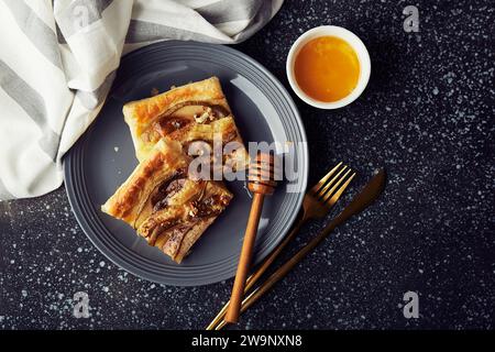 Frisch gebackenes hausgemachtes Gebäck. Blätterteigtorten mit Birnenscheiben, Camembert, Honig, Walnüssen von oben. Stockfoto