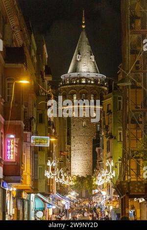 Istanbul, Türkei - 18. Oktober 2023: Blick auf das historische Wahrzeichen des Galata-Turms von der Buyuk Hendek Street im Nachtleben von Beyoglu. Stockfoto