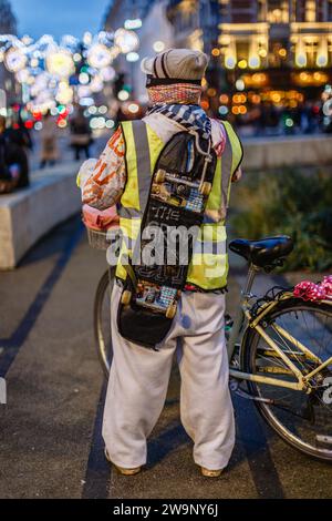 Ein Skateboarder und Radfahrer genießt den Blick auf die Weihnachtsbeleuchtung in London. Stockfoto