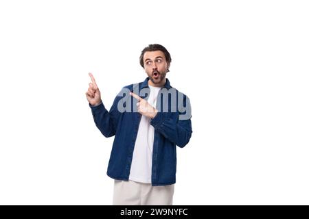 Porträt eines jungen europäischen brutalen brünetten Mannes mit coolem Haar, der auf den Zeigefinger zeigt Stockfoto