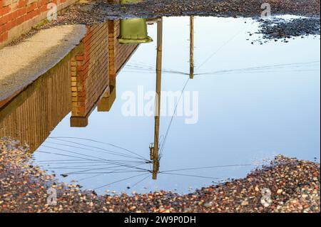 Eine große Pfütze in einer Gasse, Großbritannien Stockfoto