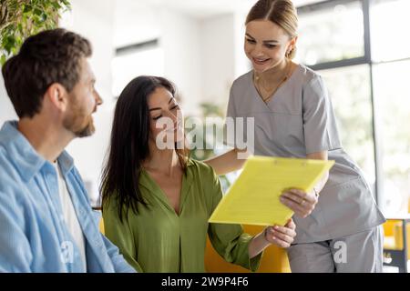 Krankenschwester kommuniziert mit Patienten im Wartezimmer einer Klinik Stockfoto