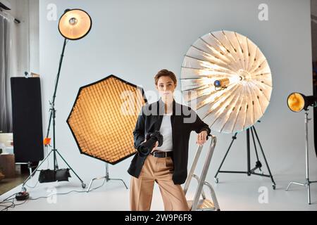 Ziemlich kurzhaarige Fotografin in lässiger Kleidung, die in ihr Studio blickt Stockfoto