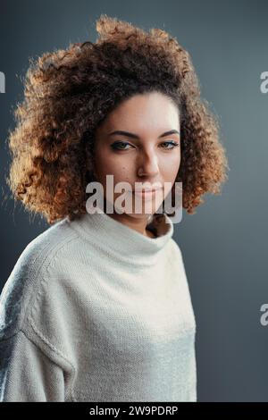 Subtiles Selbstvertrauen wird durch den gleichmäßigen Blick der Frau und den natürlichen Haarausfall vermittelt Stockfoto