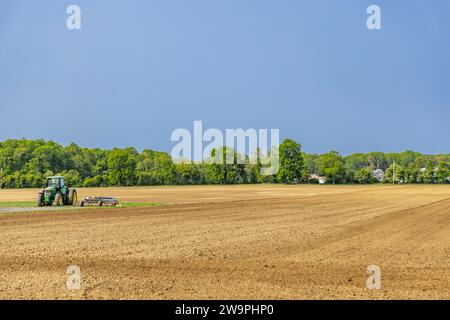 john deere Traktor sitzt auf einem frisch gepflügten Feld Stockfoto