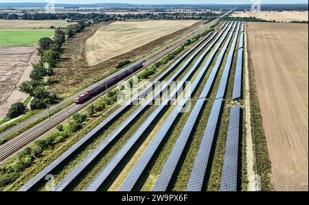 Photovoltaikanlage auf einer Bahnstrecke, vorbeifahrender Regionalexpress der Deutschen Bahn, Nauen, 15 08 2023 Stockfoto