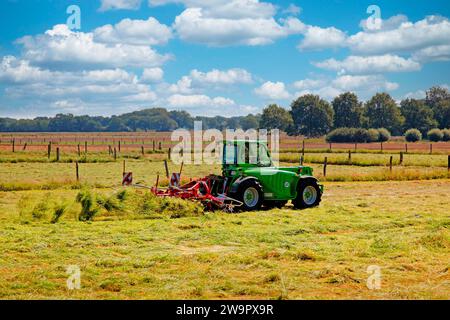 Ein Bauer mit seinem Traktor und heuschneider Stockfoto