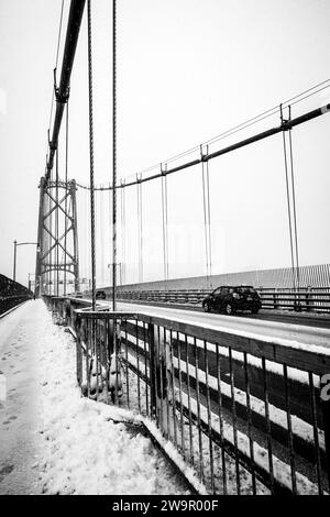 Autos überqueren die Angus-L-Macdonald-Brücke über den Hafen während eines Schneesturms in Halifax, Nova Scotia, Kanada. Stockfoto