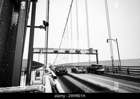 Autos überqueren die Angus-L-Macdonald-Brücke über den Hafen während eines Schneesturms in Halifax, Nova Scotia, Kanada. Stockfoto