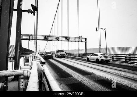 Autos überqueren die Angus-L-Macdonald-Brücke über den Hafen während eines Schneesturms in Halifax, Nova Scotia, Kanada. Stockfoto