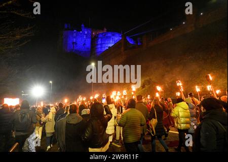 Edinburgh, Schottland, Großbritannien. Dezember 2023. Die viertägigen Hogmanay-Feierlichkeiten beginnen mit den Wikings vom Südinsel Shetlands bis zum Helly AA’Jarl Squad, der die Hogmanay-Fackelprozession mit 20.000 Menschen durch die historische Altstadt der Hauptstadt führt. Prozession auf der Johnston Terrace mit Blick auf die beleuchtete Burg. Quelle: Craig Brown/Alamy Live News Stockfoto