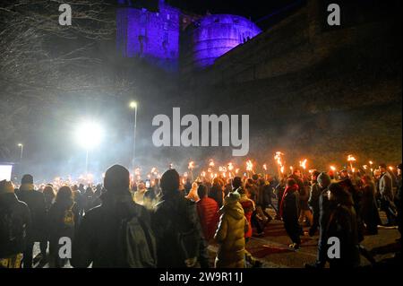 Edinburgh, Schottland, Großbritannien. Dezember 2023. Die viertägigen Hogmanay-Feierlichkeiten beginnen mit den Wikings vom Südinsel Shetlands bis zum Helly AA’Jarl Squad, der die Hogmanay-Fackelprozession mit 20.000 Menschen durch die historische Altstadt der Hauptstadt führt. Prozession auf der Johnston Terrace mit Blick auf die beleuchtete Burg. Quelle: Craig Brown/Alamy Live News Stockfoto