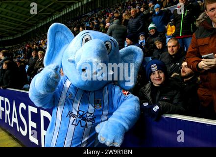 Coventry City Maskottchen Sky Blue Sam posiert für ein Foto mit einem Fan auf den Tribünen während des Sky Bet Championship Matches in der Coventry Building Society Arena in Coventry. Bilddatum: Freitag, 29. Dezember 2023. Stockfoto