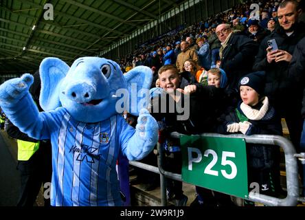 Coventry City Maskottchen Sky Blue Sam posiert für ein Foto mit einem Fan auf den Tribünen während des Sky Bet Championship Matches in der Coventry Building Society Arena in Coventry. Bilddatum: Freitag, 29. Dezember 2023. Stockfoto