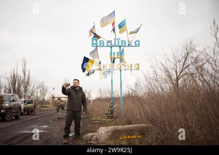 Avdiivka, Ukraine. Dezember 2023. Der ukrainische Präsident Wolodymyr Zelenskyj macht ein Selfie vor dem Schild für Avdiiwka, während eines Besuchs an den Frontlinien der Region Donezk am 29. Dezember 2023 in Avdiiwka, Oblast Donezk, Ukraine. Quelle: Pool Photo/Ukrainische Präsidentenpresse/Alamy Live News Stockfoto