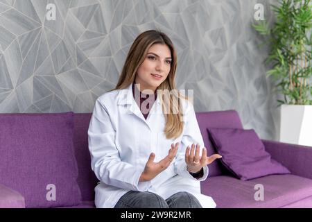 Junger Latina-Psychologe, der auf einer Couch eine Therapie gibt. Psychische Gesundheit im neuen Jahr Stockfoto