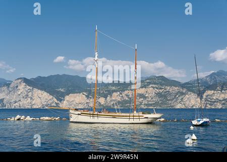 Segelyacht für Ausflüge mit Touristen auf dem Gardasee in der Nähe von Malcesine in Italien mit den Alpen im Hintergrund Stockfoto