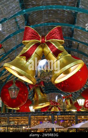 Weihnachtsbeleuchtung im Covent Garden Market in London 2023 in Form von Glocken und Bändern Stockfoto