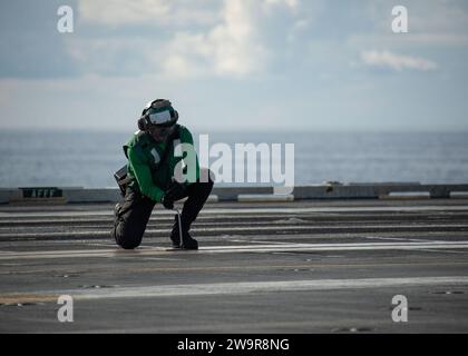 Die Airman Rasean Card, worldÕs die der Luftbehörde des größten Flugzeugträgers USS Gerald R. Ford (CVN 78) zugewiesen wurde, sichert die Katapulte für die Bergung von Flugzeugen auf dem Cockpit während des Routinebetriebs am 11. Dezember 2023. Die Gerald R. Ford Carrier Strike Group ist derzeit im Mittelmeer tätig. Die USA halten nach vorne entsandte, bereitwillige und positionierte Kräfte bereit, um Aggressionen abzuschrecken und Sicherheit und Stabilität auf der ganzen Welt zu unterstützen. (Foto der US Navy von Mass Communication Specialist 2nd Class Nolan Pennington) Stockfoto