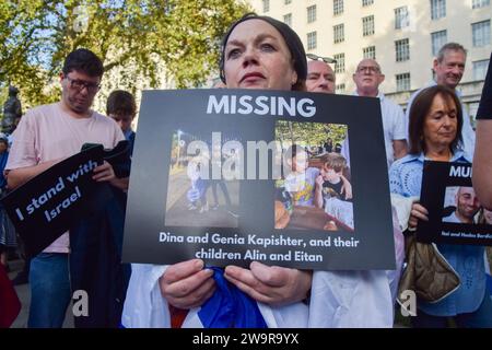 London, Großbritannien. Oktober 2023. Eine Frau hält ein Schild hoch, auf dem steht: "VERMISSTE Dina und Genia Kapishter und ihre Kinder Alix und Eitan", das sie zwischen Text zeigt. Vor der Downing Street versammeln sich viele Demonstranten, um Israel zu unterstützen, während nach dem Angriff der Hamas auf Israel ein Krieg ausbricht. (Kreditbild: © Vuk Valcic/ZUMA Press Wire) NUR REDAKTIONELLE VERWENDUNG! Nicht für kommerzielle ZWECKE! Stockfoto