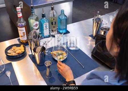 Besucher der Bombay Sapphire Destillerie, die einen Gin Tonic Cocktail mit Barausstattung bei einer Cocktail-Masterclass in Laverstoke Mill, Whitchurch, Großbritannien, mixte Stockfoto