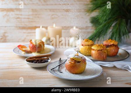 Puderzucker wird auf einen gebackenen Apfel gestreut, der mit Mandeln, Marzipan und Honig gefüllt ist, mit Vanille, Zimt und Orangenschale gewürzt, festlich Stockfoto