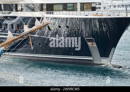 Sonnenstrahlen auf Hochglanzbrett der Mega-Yacht, Anker, Ruhe im Hafen Herkules, Bug des vertäuten riesigen Bootes an sonnigen Tagen, Monaco, Monte-Carlo Stockfoto