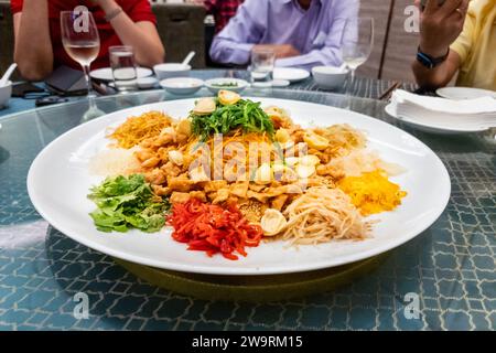 Im Restaurant wird während der chinesischen Neujahrsfeier mit Abalone gesungen, während die Gäste sitzen. Stockfoto