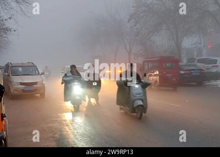 ANYANG, CHINA - 30. DEZEMBER 2023 - Menschen reisen in starkem Nebel mit einer Sichtweite von weniger als 200 Metern in Hua County, Stadt Anyang, Provinz Henan, Chi Stockfoto